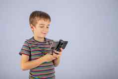 男孩微笑智能手机屏幕平原蓝色的背景的地方复制