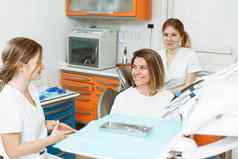 医疗牙医团队会说话的病人女人会说话的牙科诊所办公室准备治疗女牙医助理牙科办公室会说话的女病人