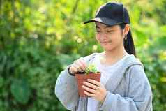 亚洲女孩持有年轻的植物阳光绿色自然背景储蓄世界地球一天概念
