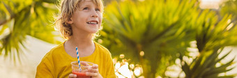 男孩喝健康的冰沙背景棕榈树西瓜冰沙健康的营养维生素孩子们横幅长格式