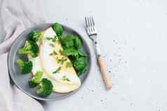 蛋白质煎蛋卷西兰花绿色灰色的板叉灰色的背景健康的食物概念复制空间