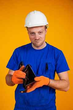 超重工人保护头盔显示空钱包经济衰退经济男人。连身裤钱经济衰退经济危机失业