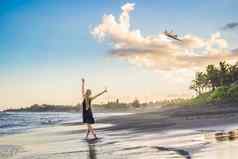 年轻的女人发射风筝海滩梦想愿望未来计划