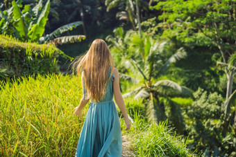 美丽的年轻的女人走典型的亚洲山坡上大米农业山形状绿色级联大米场梯田稻田乌布巴厘岛印尼巴厘岛旅行概念