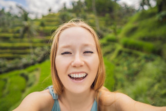 美丽的年轻的女人走典型的亚洲山坡上大米农业山形状绿色级联大米场梯田稻田乌布巴厘岛印尼巴厘岛旅行概念