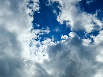 美丽的毛茸茸的白色云形成深蓝色的夏天天空