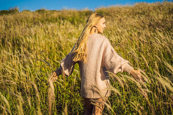 年轻的美丽的女人秋天景观干花小麦峰值时尚秋天冬天阳光明媚的秋天舒适的秋天毛衣时尚照片