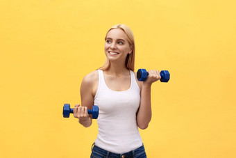健身女人提升权重微笑快乐孤立的黄色的背景适合运动高加索人女健身模型