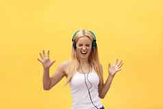 生活方式肖像快乐女人听音乐耳机孤立的黄色的背景