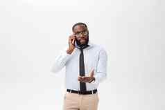 肖像困惑年轻的非洲男人。穿着白色衬衫会说话的移动电话手势孤立的白色背景