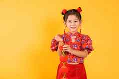 快乐亚洲中国人女孩微笑穿红色的旗袍旗袍持有丝绸灯笼