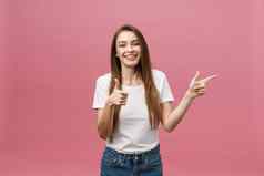 照片快乐年轻的女人站泊亭手指孤立的粉红色的背景