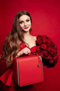 时尚的华丽的浅黑肤色的女人红色的红色的玫瑰红色的袋