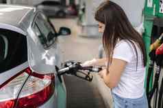有吸引力的年轻的女人加油车气体站女填充柴油汽油燃料车燃料喷嘴汽油概念一边视图燃料短缺乌克兰