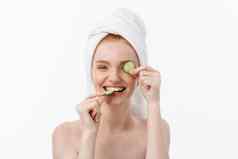有吸引力的年轻的女人美丽的清洁皮肤白色面具黄瓜美治疗美容水疗中心治疗白色背景