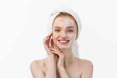 美丽的模型应用化妆品奶油治疗脸白色