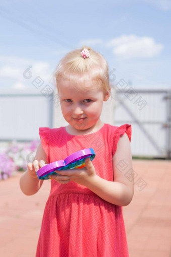 可爱的高加索人公平头发女孩粉红色的衣服玩显示有趣的时尚的硅胶抗应激色彩斑斓的玩具喝
