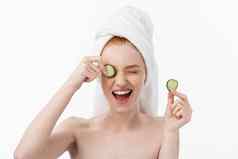 有吸引力的年轻的女人美丽的清洁皮肤白色面具黄瓜美治疗美容水疗中心治疗白色背景