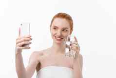 快乐微笑年轻的女人健康的皮肤阅读写作移动电话短信喝清洁水咨询饮食特写镜头肖像