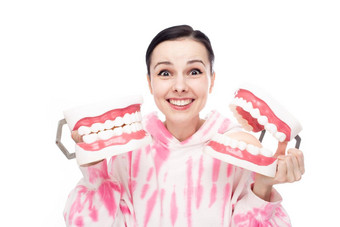快乐女人粉红色的运动衫持有牙科<strong>实物</strong>模型下巴手
