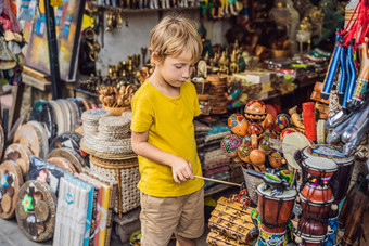 男孩市场乌布巴厘岛典型的纪念品商店销售记忆手工艺品巴厘岛著名的乌布市场印尼巴厘岛的市<strong>场记</strong>忆木工艺品当地的居民旅行孩子们概念孩子们友好的的地方
