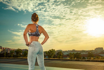 运动女人适合身体运动服装摆姿势天空背景<strong>运行</strong>跟踪回来视图