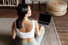 正念冥想概念后视图年轻的亚洲女人冥想首页在线移动PC坐着生活房间地板上席