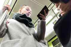 年轻的女人乘客智能手机移动现代地铁通勤公共运输