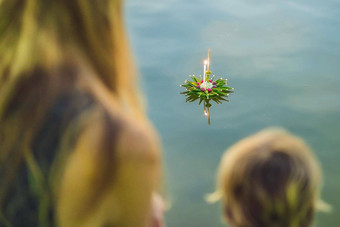 妈妈儿子游客持有阿来水灯手发射水阿来水灯节日人买花蜡烛光浮动水庆祝阿来水灯节日泰国