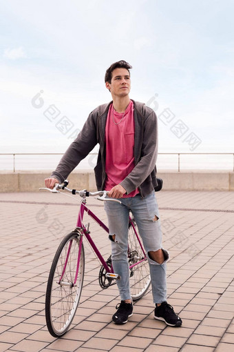 英俊的年轻的男人。走古董自行车