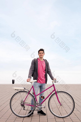快乐年轻的男人。持有古董自行车