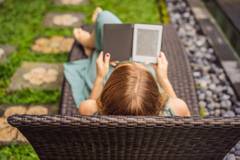 女人读取电子书甲板椅子花园