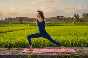 年轻的女人<strong>实践</strong>瑜伽<strong>户外</strong>大米字段早....健康撤退巴厘岛