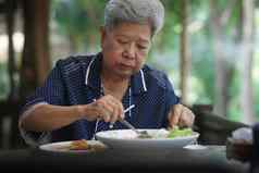 上了年纪的高级女人吃食物阳台成熟的退休生活方式