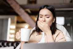 肖像生病的亚洲女人首页咳嗽喝热茶捕捉流感新冠病毒