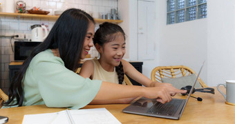 自主学习亚洲妈妈。年轻的女孩学生学习在线类电子学习在线教育概念