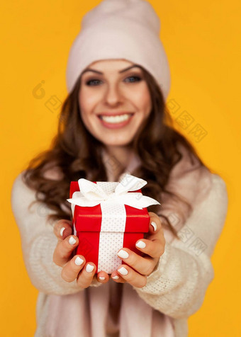 快乐年轻的微笑女人持有持有红色的礼物盒子