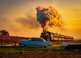视图古董蒸汽乘客火车接近日出完整的头蒸汽烟