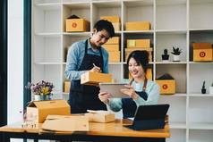 亚洲夫妇在线业务首页帮助包产品纸板盒子家庭概念现代业务小企业家在线交付