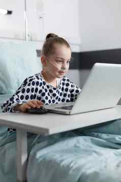 微笑生病的女孩玩游戏电脑移动PC儿科诊所复苏病房房间