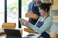 亚洲夫妇在线业务首页帮助包产品纸板盒子家庭概念现代业务小企业家在线交付