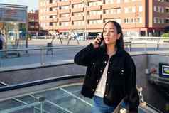 年轻的女人出口地铁站会说话的电话