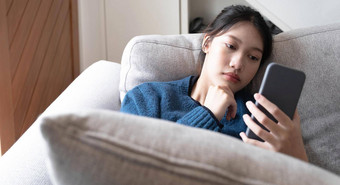 亚洲躺沙发上生活房间沮丧慢互联网连接垃圾邮件智能手机