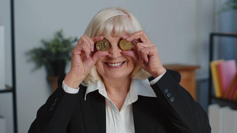 上了年纪的女商人显示金<strong>比特币比特币</strong>钱矿业投资财富收入收入