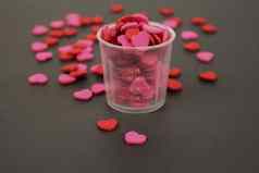 红色的粉红色的心糖果透明的杯黑暗背景爱情人节概念