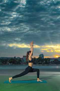 女人练习瑜伽户外美丽的女孩实践体式在线类冷静放松背景日落