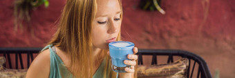 年轻的女人地中海早餐坐着沙发饮料时尚的喝蓝色的拿铁热蝴蝶(2008年)拿铁蓝色的螺旋藻拿铁横幅长格式