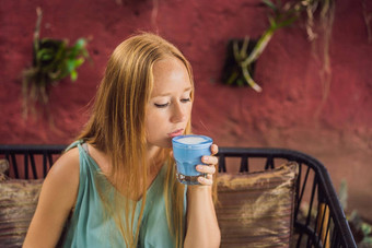年轻的女人地中海早餐坐着沙发饮料时尚的喝蓝色的<strong>拿</strong>铁热蝴蝶(2008年)<strong>拿</strong>铁蓝色的螺旋藻<strong>拿</strong>铁