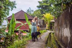 巴厘岛狗妈妈。儿子游客巴厘岛走狭窄的舒适的街道乌布巴厘岛受欢迎的旅游目的地旅行巴厘岛概念旅行孩子们概念