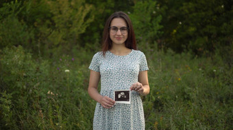年轻的怀孕了女人持有超声波<strong>图片婴儿</strong>手女孩眼镜衣服自然